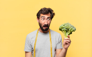 young crazy bearded man dieting sad expression and holding a cabbage