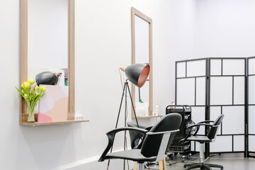 The interior of the modern hairdressing salon with a professional chairs and equipment is ready to receive visitors.