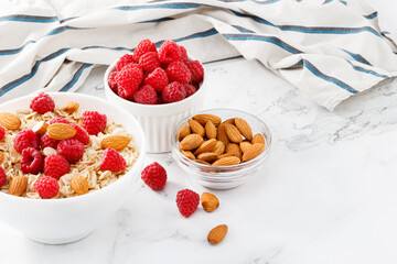 Healthy breakfast. Bowl with oatmeal with fresh raspberries and almonds. Copy space