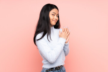 Teenager Chinese woman isolated on pink background scheming something