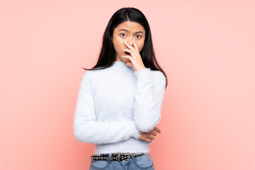 Teenager Chinese woman isolated on pink background surprised and shocked while looking right