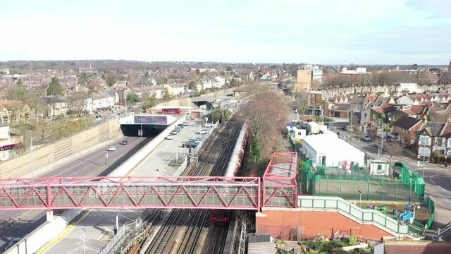 LONDON UNDERGROUND TRAIN MOVING PARALELL TO DUAL CARIAGE HIGH WAY AERIAL.