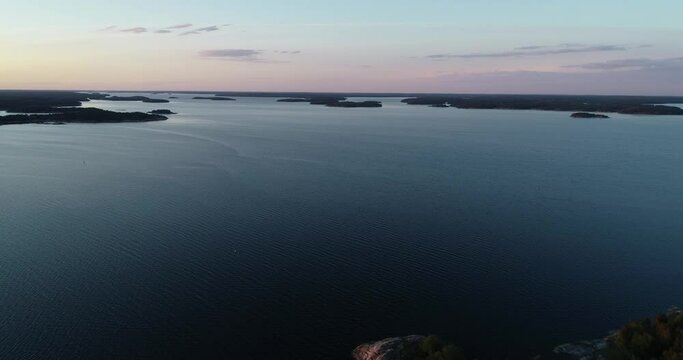 Colorful sunset sky above silhouette islands in the archipelago. Saaristomeri. Aerial drone view.