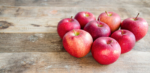 A bunch of red apples on a vintage, wooden background. Rustic style. The fruit is on the table. A healthy and vitamin snack.