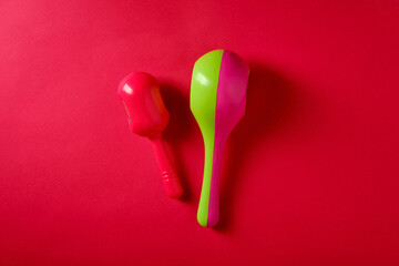 Multicolored baby rattles on a red background, top view