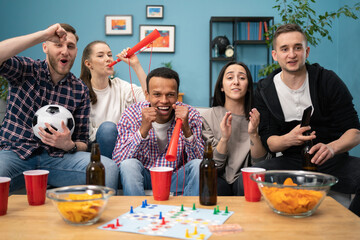 Happy friends or football fans watching soccer on tv and celebrating victory at home. Friendship, sports and entertainment concept.