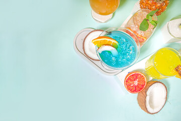 Colorful summer drinks set. Various bright alcohol cocktails and beverages, in different glasses, with tropical fruit on modern bright background copy space