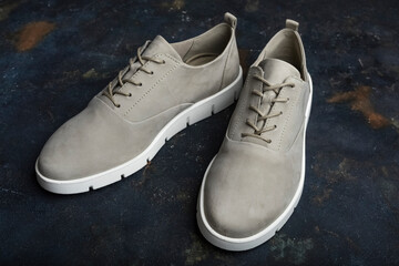 Stylish gray shoes on a blue background. Comfortable shoes for women, close-up. Beauty and Fashion Concept