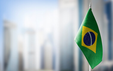 A small flag of Brazil on the background of a blurred background