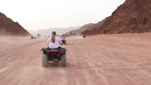 Quad bike ride through the desert near Sharm el Sheikh, Egypt.Adventures of desert off-road on ATV.Sand and Sand Borkhan. Rock and sunset. Quad Cycle Travel. Excursion with people.