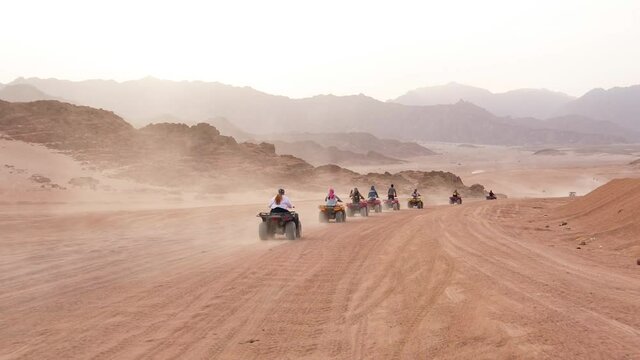 Quad bike ride through the desert near Sharm el Sheikh, Egypt.Adventures of desert off-road on ATV.Sand and Sand Borkhan. Rock and sunset. Quad Cycle Travel. Excursion with people.