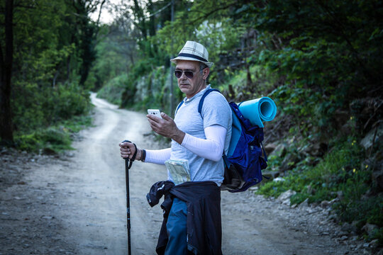 mountaineer hiking consulting the phone on the way