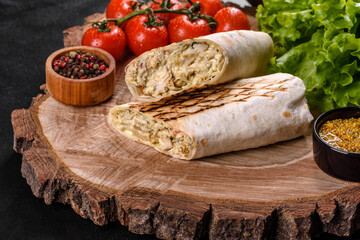 Delicious fresh shawarma with meat and vegetables on a dark concrete table