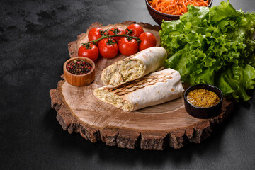 Delicious fresh shawarma with meat and vegetables on a dark concrete table