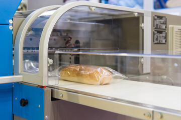 White bread in plastic packaging on conveyor for packaging 