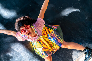 Young woman behaving crazy wearing holographic clothes