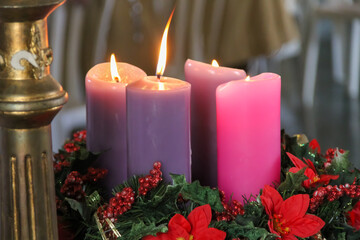 Four purple candles lit over an advent wreath for Sunday Mass in the church