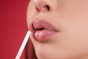 Naklejka premium Nude lips closeup. Makeup beauty. Lips lipstick closeup. Applying make up on lip. Pampering, lips correction concept.