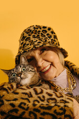Woman bonding to her striped cat, while holding her pet on hands
