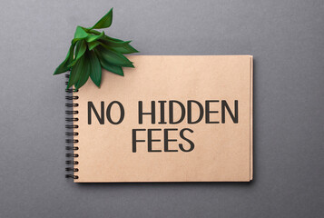 No Hidden Fees text on craft colored notepad and green plant on the dark background
