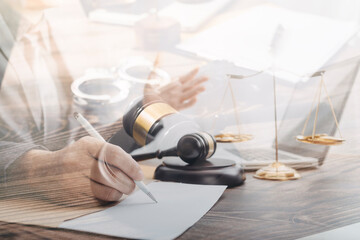 Justice and law concept.Male judge in a courtroom with the gavel, working with, computer and docking keyboard, eyeglasses, on table in morning light