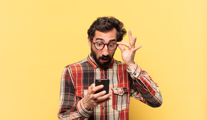 young crazy bearded man scared expression and holding a phone