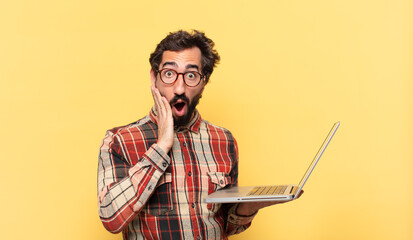 young crazy bearded man surprised expression and a laptop