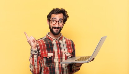 young crazy bearded man celebrating successful a victory and a laptop