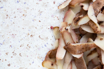 Fresh potato peelings on the table. Made in natural light, soft shadows.
