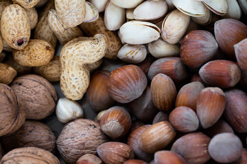 Pistachios, walnuts, hazelnuts, and peanuts in one bowl. Natural, soft light