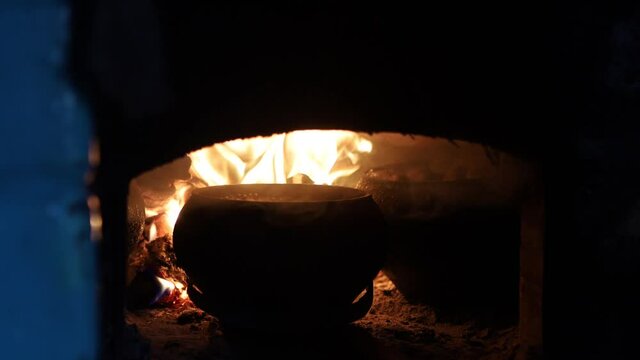 cooking on the fire of a home rustic oven chowder soup in a pot.
