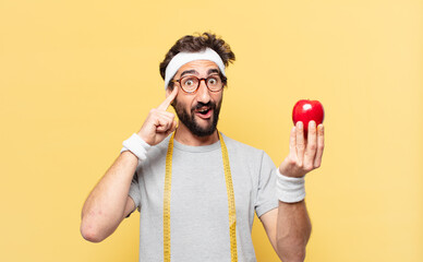young crazy bearded athlete thinking expression and holding an apple and holding an apple