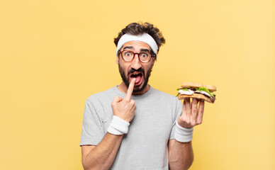 young crazy bearded athlete sad expression and holding a sandwich