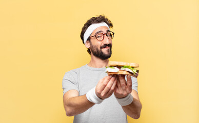 young crazy bearded athlete happy expression and holding a sandwich
