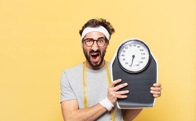 young crazy bearded athlete angry expression and holding a scale
