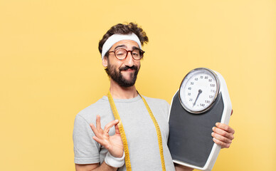 young crazy bearded athlete happy expression and holding a scale