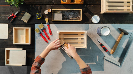 Top view of unrecognizable woman making wooden boxes, small business and desktop concept.