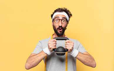 young crazy bearded athlete surprised expression and lifting a dumbbell