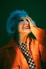Woman dressed at fashionable clothes amused by humorous joke and laughing