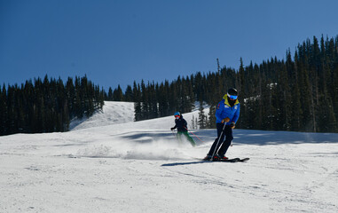 Skier going down the slopes on hi-speed at sunny day with fresh show at Vail ski resort, Colorado