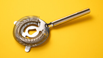 Sieve for cocktails. Cocktail strainer on yellow background. Bartender strainer. Bartender tools