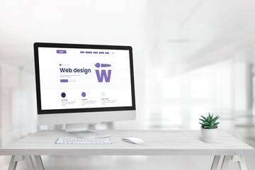 Web design studio with promo page on computer display and copy space beside