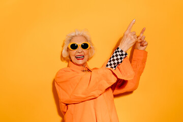 Woman smiling joyfully to the camera and pointing up with the fingers