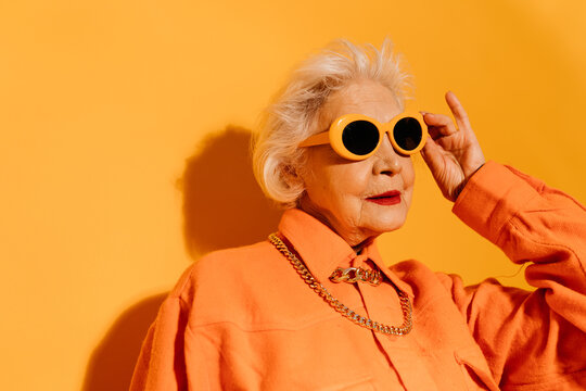 Woman looking away and holding hands at her sunglasses