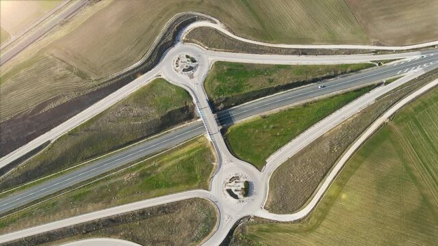 Aerial drone view over a country road junction intersection. Traffic on flyover at rural scenery. High quality 4k footage