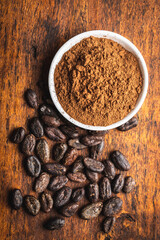 Roasted cocoa beans and cocoa powder in bowl