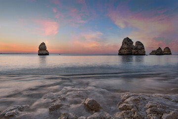 A scenic sunrise on a beautiful beach with rocks near Lagos, Algarve, Portugal