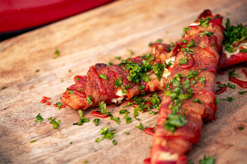 Sweet red pepper stuffed with cream cheese, wrapped in bacon and grilled