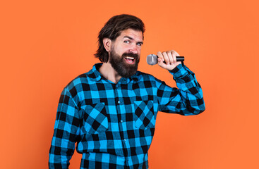 brutal man in checkered shirt has long beard sing in microphone, music