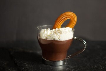 Dipping traditional Spanish sweet called Churros in hot chocolate